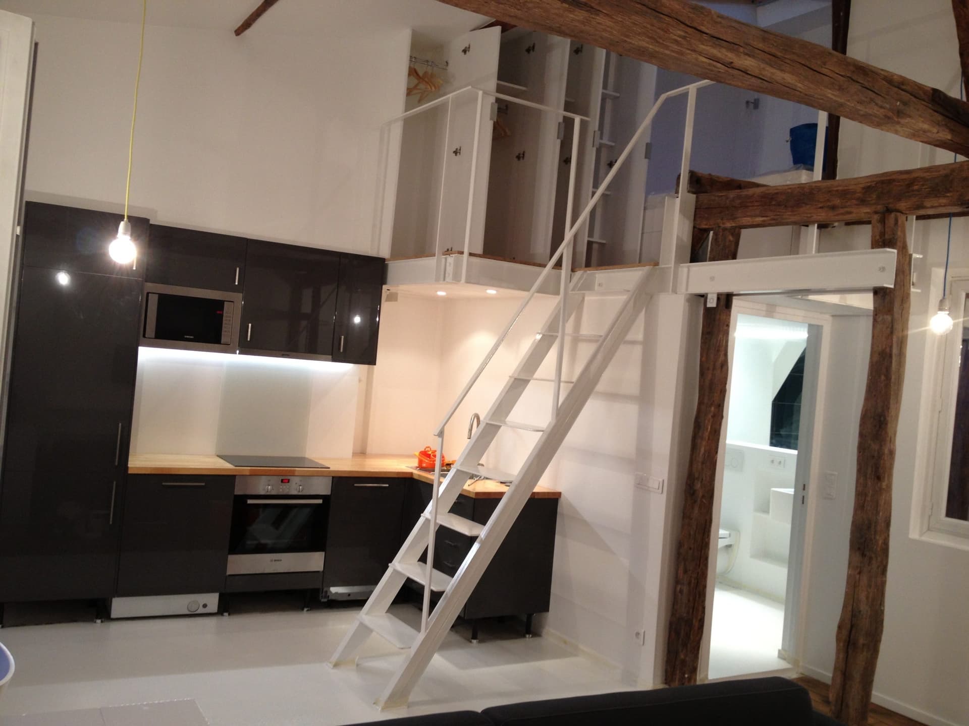 Rénovation duplex sous combles Paris 11e avec cuisine contemporaine laquée et poutres sablées